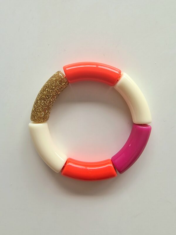 Le bracelet rose est composé de 2 perles orange, une perle fuchsia, 2 perles blanches et 1 perle pailletée